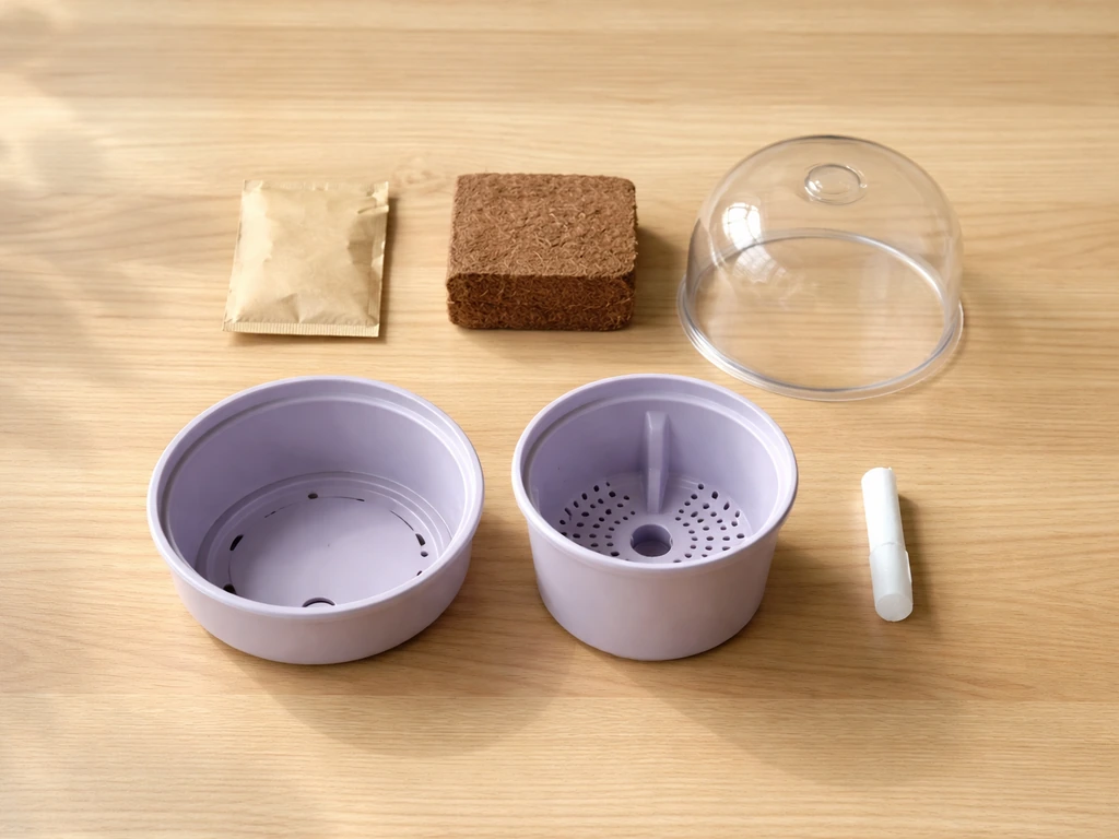 Top-down flat lay of a lavender grow kit with seed packet, coconut medium, planter parts, and optional dome/wick.